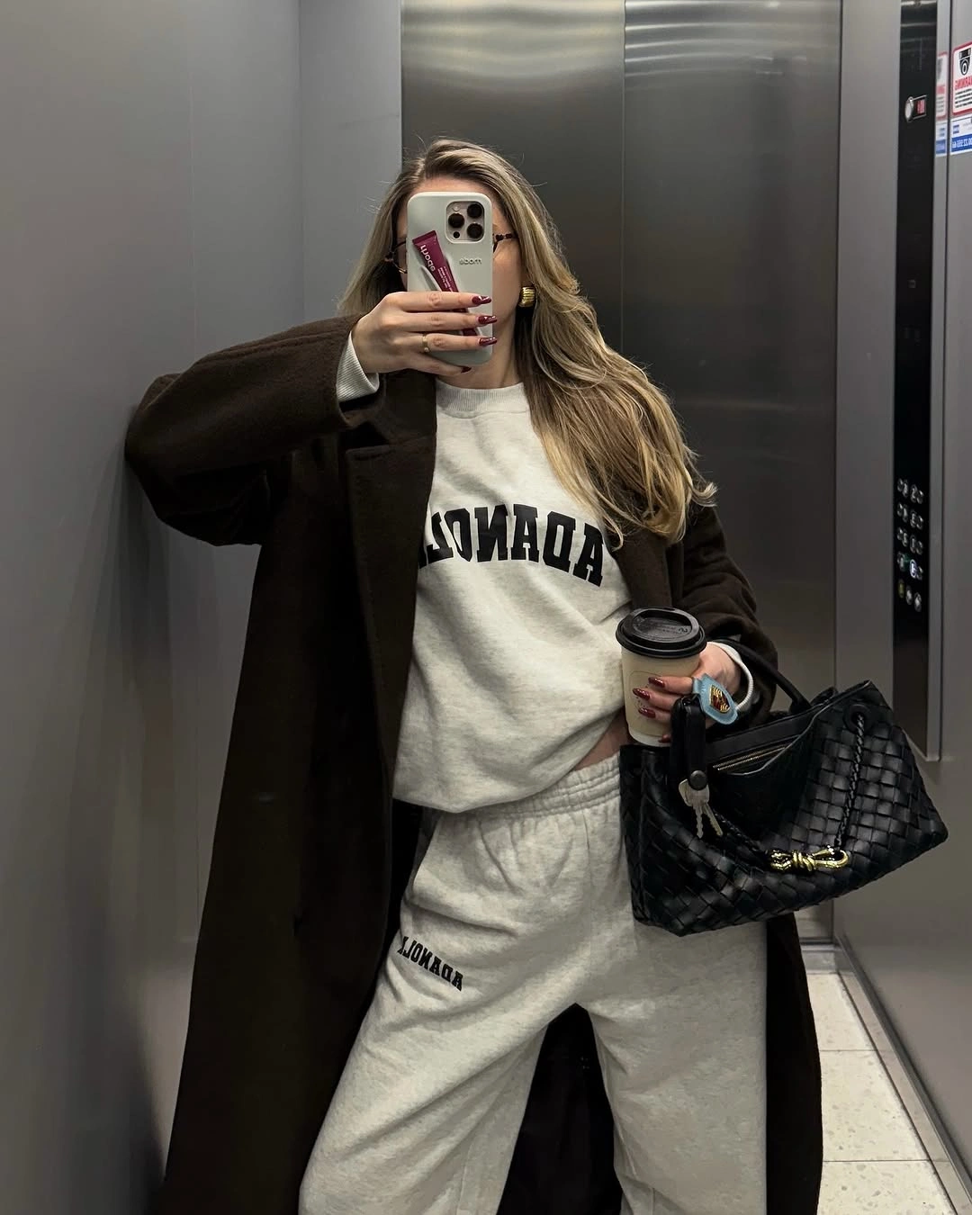 Gray sweatshirt and joggers under long brown coat