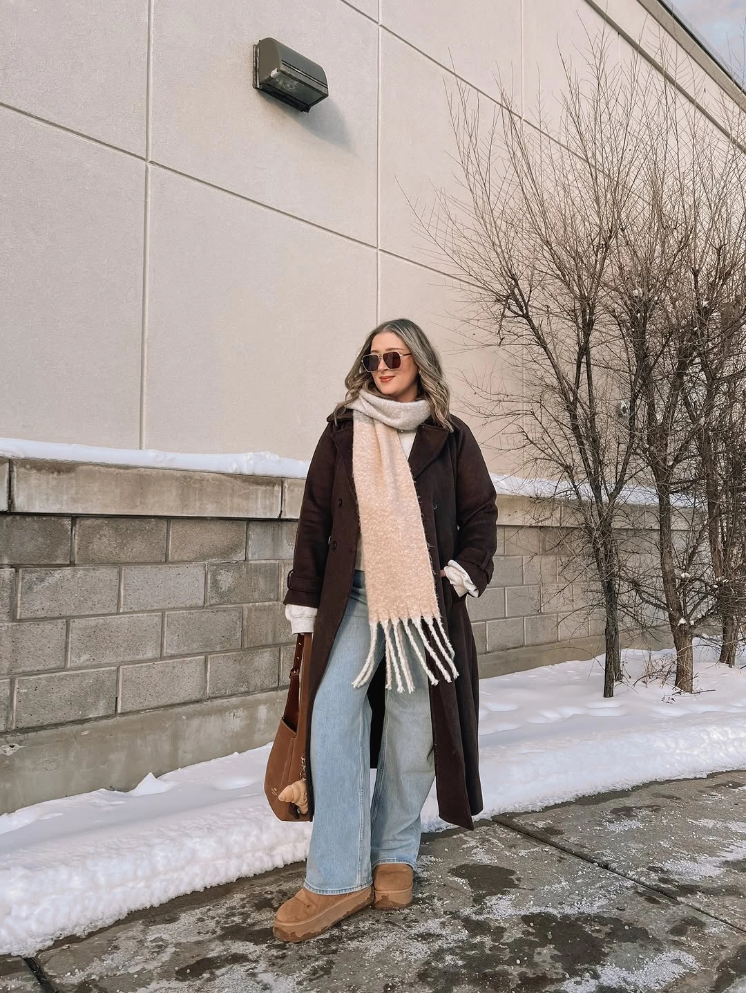 Brown long coat with cream scarf and pale jeans
