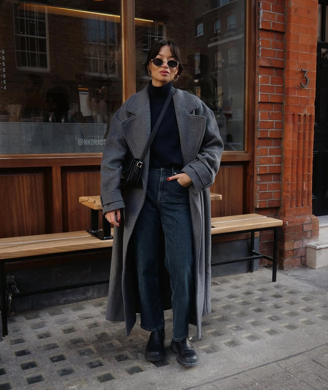 Oversized gray coat over dark top and trousers