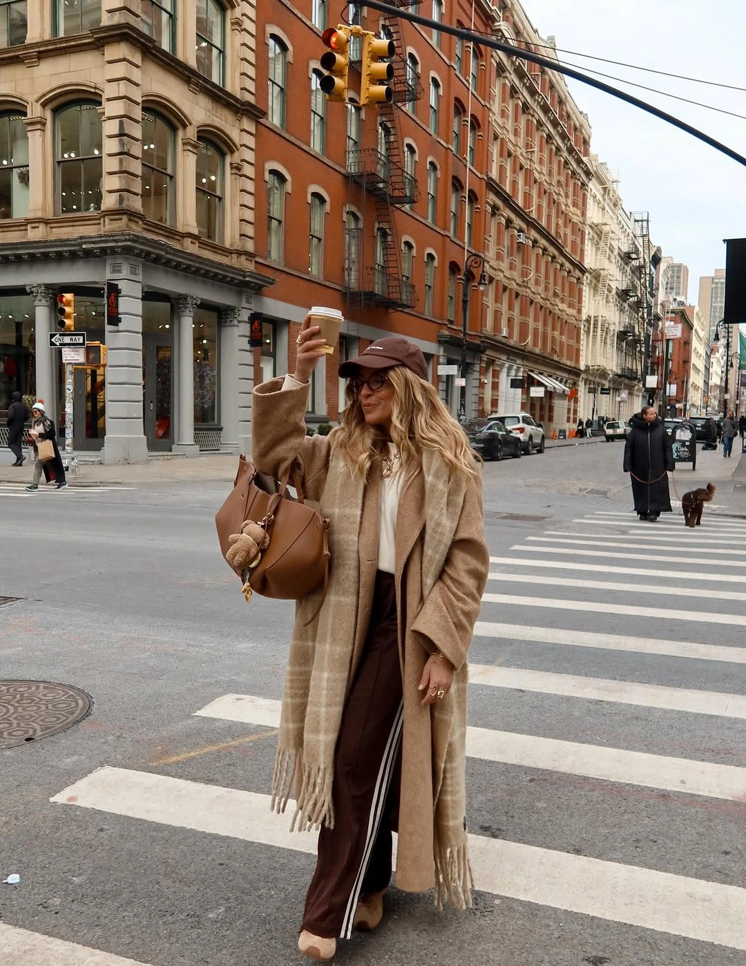 Tan coat with checked scarf, brown cap and handbag