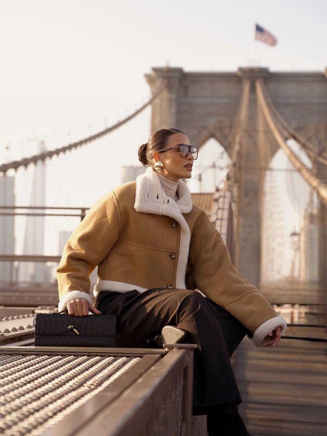 Tan jacket with white plush trim and dark wide trousers