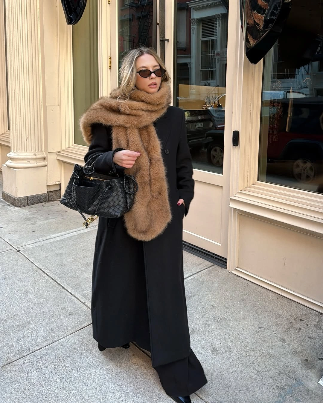 Long black coat with brown plush wrap and quilted handbag