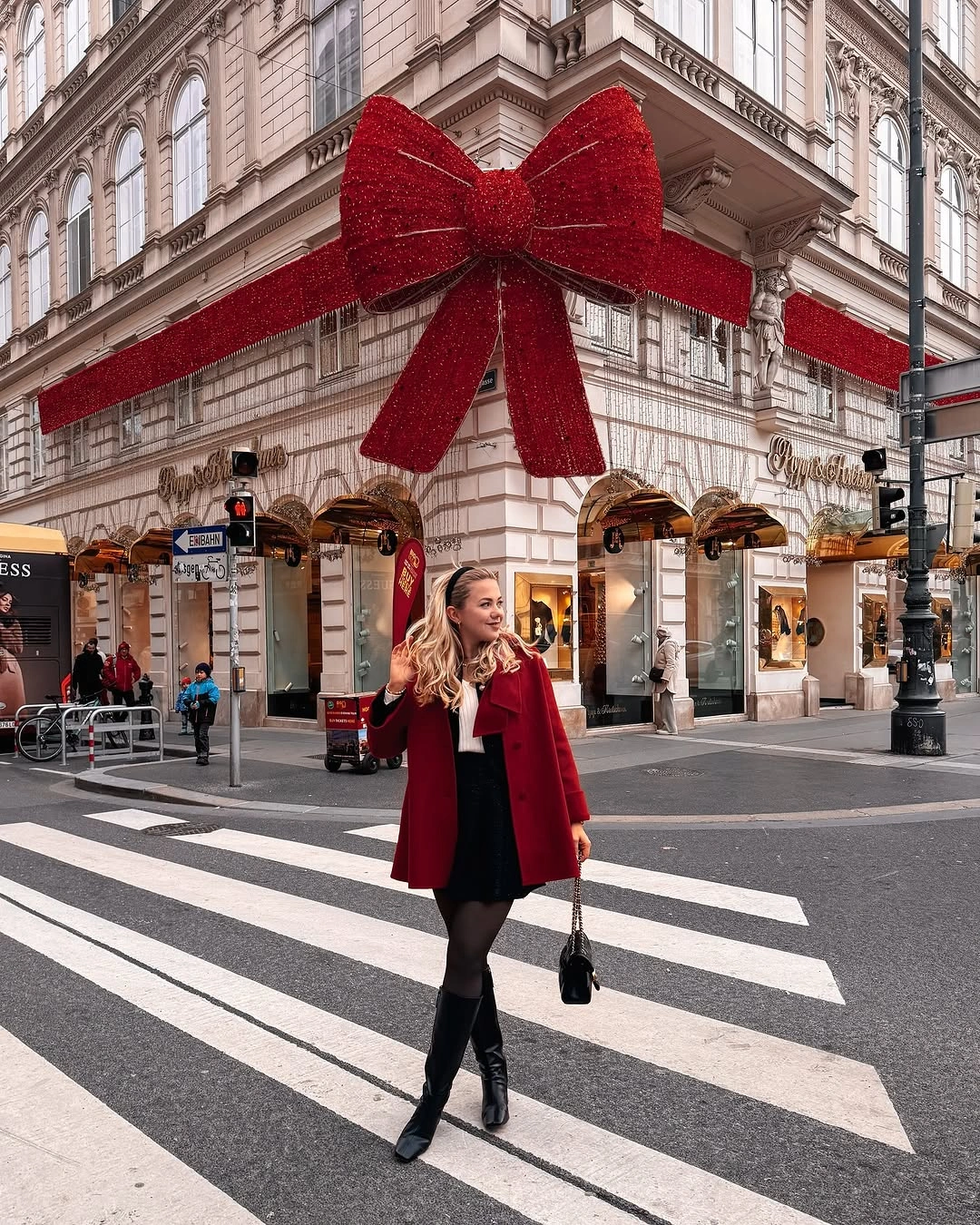 Red coat with black knee-high boots and pale scarf