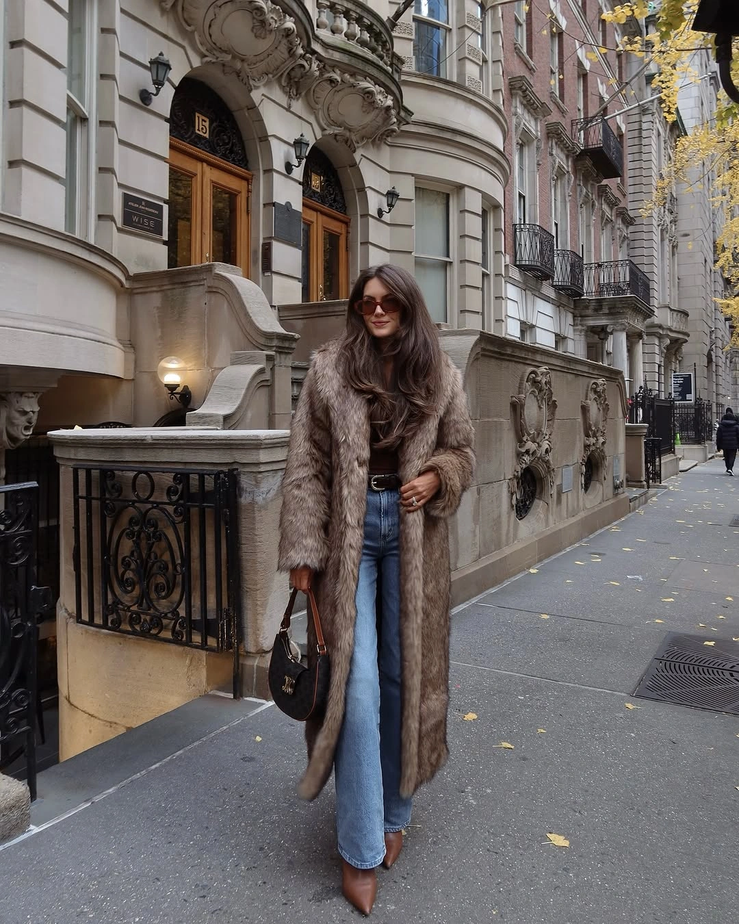 Shaggy taupe-gray coat with blue jeans and brown pointed boots