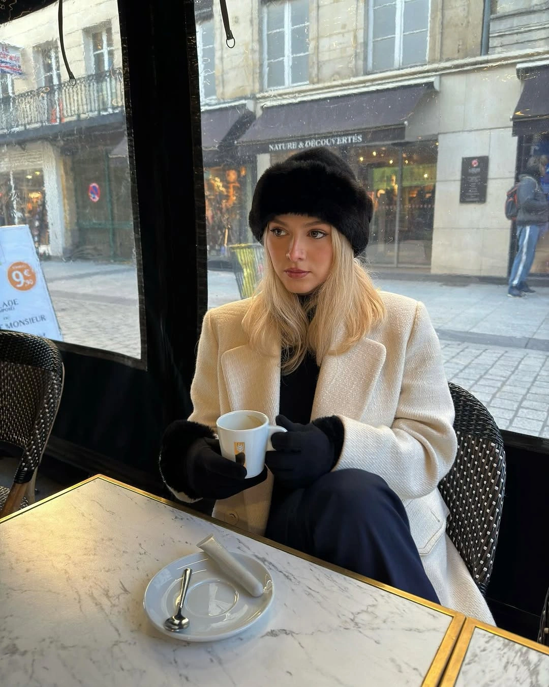 Oversized cream coat with white trousers and light sneakers