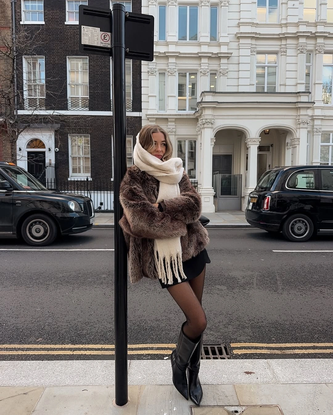 Brown fuzzy jacket, cream scarf and pointed black knee boots