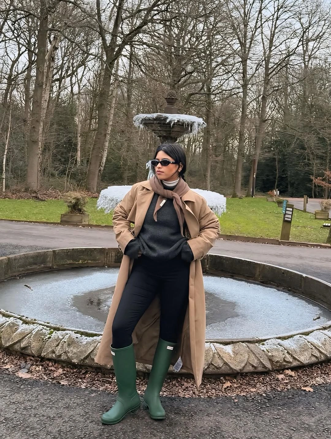 Beige coat, charcoal sweater, black pants and green boots