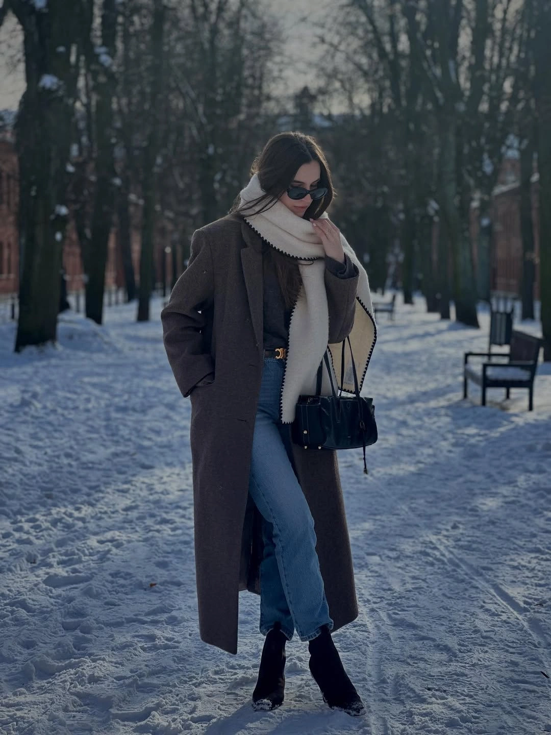 Long brown coat, cream scarf, jeans and black ankle boots